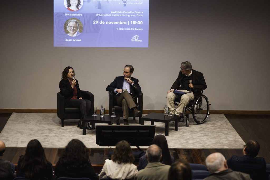 imagem da sessão de apresentação do livro no Porto. Três autores no palco e plateia a assistir, uma das pessoas em cadeira de rodas
